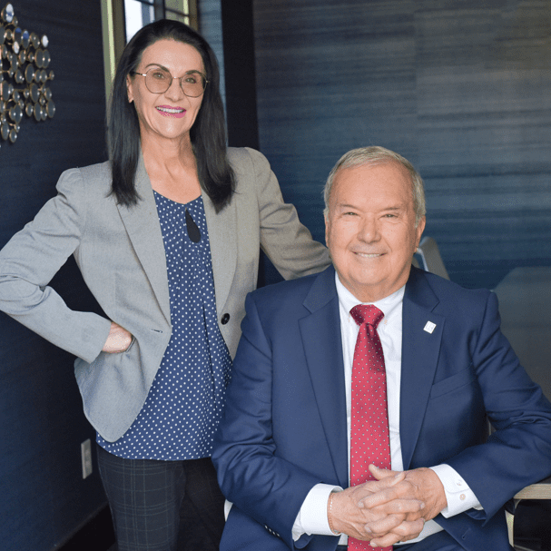 Smiling businesswoman standing beside seated businessman